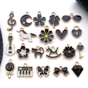 Macro view of assorted black enamel charms including hearts and music notes