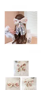 Detailed embroidery of pink roses on ivory lace bow hair clip with vintage mesh fabric