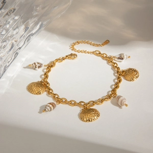 Golden summer bracelet featuring sea shells and conch pendants with dynamic water ripples
