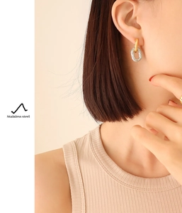 Detail of two-tone gold and silver twisted oval earrings made of durable stainless steel
