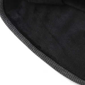 Close-up of soft black fleece lining with grey ribbed knit edge on a beanie hat