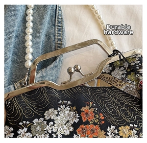 Detail of silver clasp and pearl handle on vintage floral jacquard shell bag