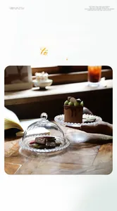 Detail of beaded edge glass dessert plate with transparent dome lid on wooden table