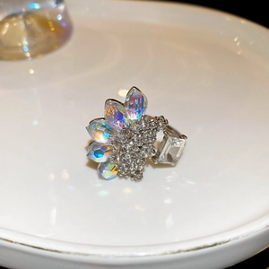 Macro shot of silver floral ring with marquise iridescent crystals on white tray