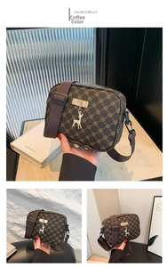 Close-up of coffee brown crossbody bag with geometric pattern and golden deer charm