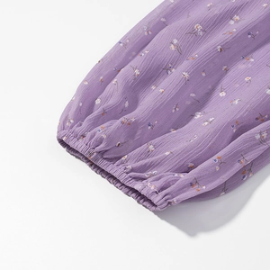 Dettaglio delle maniche in chiffon floreale viola con polsini elastici