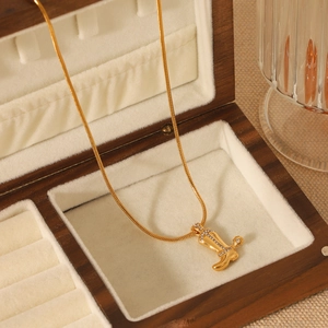 Collier en acier doré avec pendentif botte de cow-boy serti de diamants sur écrin bois