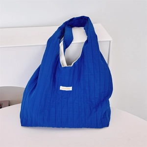 Detailed texture of royal blue pleated tote bag fabric with Sasakku brand label detail