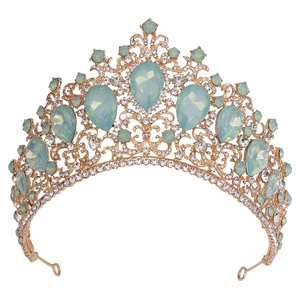 Detailed view of the gold tiara featuring large light green teardrop gemstones and rhinestones