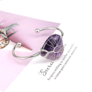 Macro detail of handmade silver wire wrapped natural purple amethyst heart open bangle