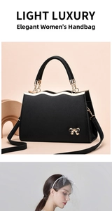 Detail of black crossbody bag with golden bow hardware and crosshatch leather texture