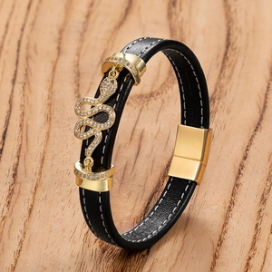 Bracelet pour homme en cuir noir avec boucle serpent dorée et strass sur fond de bois