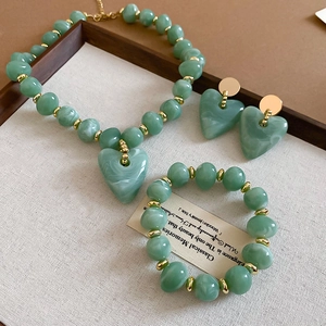 Detail of light green acrylic heart jewelry set with necklace, bracelet and earrings