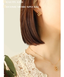 Detail of gold geometric bead necklace and earrings set worn by a fashion model