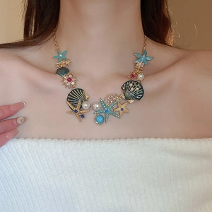 Detail of nautical necklace featuring blue starfish, shells, pearls and turquoise accents