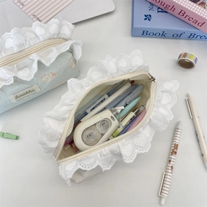 Lace-trimmed canvas pencil case showing capacity with pens and stationery inside