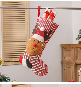 Detail view of a striped Christmas stocking with a 3D reindeer hanging by the fireplace