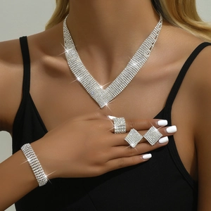 Detail shot of a sparkling silver V-shaped rhinestone bridal jewelry set worn by a model