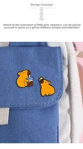 Detail showing two capybara enamel pins with boba tea and butterfly on a blue canvas bag