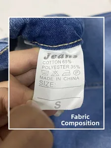 Detailed view of the 65% cotton care label and material composition for denim jeans
