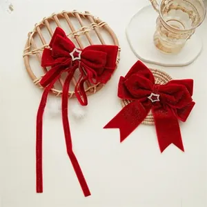 Detail of red velvet bow hair ties with star rhinestones and festive fur ball tassels