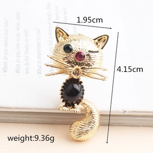 Exquisite gold-toned cat brooch with green gemstone eyes and black oval body stone