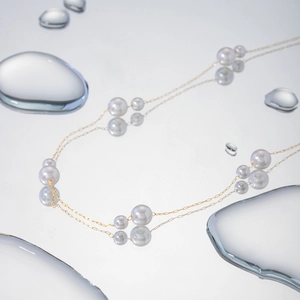 Macro detail of 18k gold stainless steel necklace featuring elegant spaced white pearls