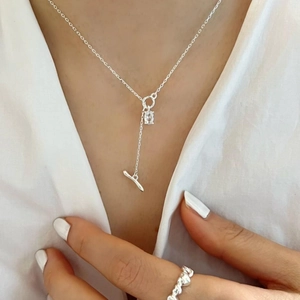 Close-up of a 925 silver toggle necklace with rectangular crystal on white shirt