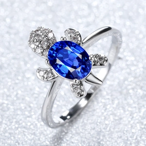 Macro shot of silver turtle ring featuring oval blue gemstone and shimmering zircon details