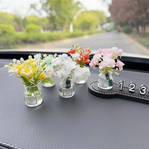 Car dashboard ornament featuring mini glass vases with colorful faux flowers and phone plate