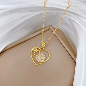 Elegant gold hollow heart necklace with sparkling crystals on white silk background