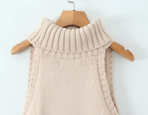 Close-up of beige knit turtleneck vest with soft thick texture on wooden hanger