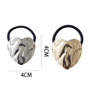 Minimalist heart-shaped hair ties in gold and silver finish with wavy metal texture