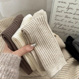 Detailed texture of thick ribbed knit wool socks in warm earth tones for winter