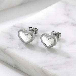 Dettaglio macro di orecchini a cuore in acciaio inossidabile con intarsio in conchiglia