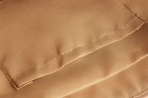 Detailed macro view of the precise stitching and texture on the brown woven beach bag