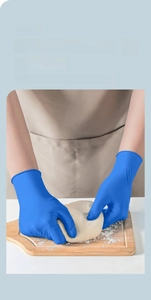 Detailed close-up of blue nitrile gloves kneading dough with SGS food grade certification