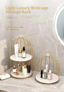 Detail of birdcage cosmetic organizer with gold metal frame and marble texture base