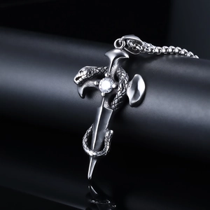 Close-up of gothic sword and snake pendant with sparkling crystal inlay and silver chain