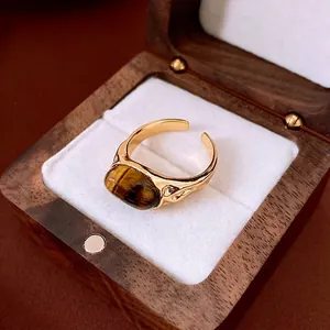 Vintage gold plated open ring with oval tiger eye stone on wood jewelry box