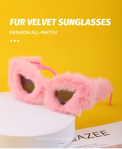 Detailed view of pink fur velvet frame sunglasses on a minimalist white display