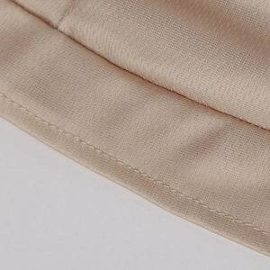 Close-up of champagne satin fabric with neat edge stitching and premium texture details