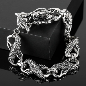 Détail d'un bracelet dragon en acier argenté avec finition antique sur miroir noir