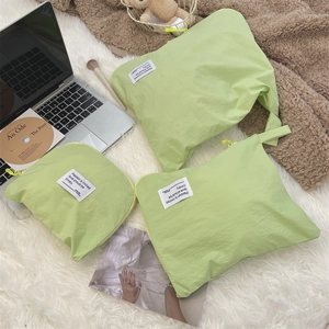 Three-piece pale green waterproof travel organizer set featuring nylon bags in a cozy setting