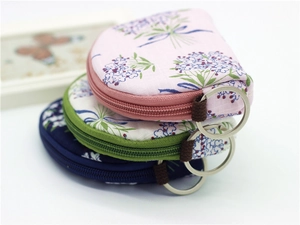Detail of semi-circular floral fabric coin purses with zippers and metal keyrings