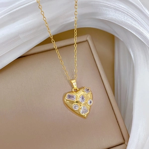Detailed macro view of a gold titanium heart pendant with assorted crystals in a gift box