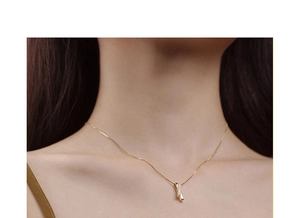 Close-up of elegant gold geometric necklace with sparkling zircon stone on model