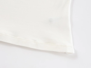 Detailed view of the double-needle stitched hem on a white U-neck cotton sports T-shirt