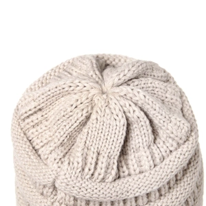 Close-up of beige chunky knit beanie showing the detailed stitching and top closure
