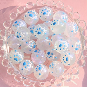Détail de perles en verre lumineux de 16mm avec motifs de pattes de chat bleues et blanches